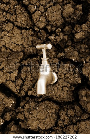 Water source concept, faucet on dry soil texture