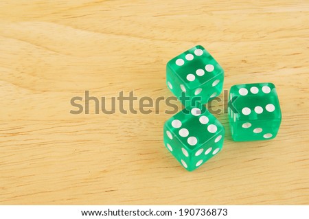 Three dices on wooden table with space for text