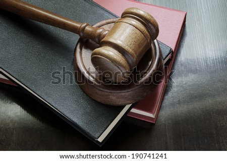 Judge's gavel and legal books on wooden table