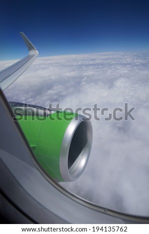 View from airplane window with blue sky and white clouds with room for text