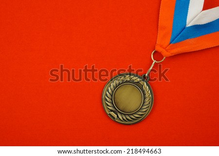 Gold medal with ribbon on red velveteen with room for text