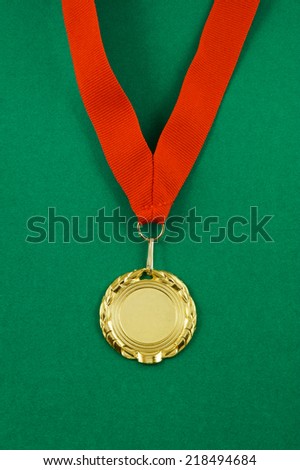 Gold medal with red ribbon on green velveteen