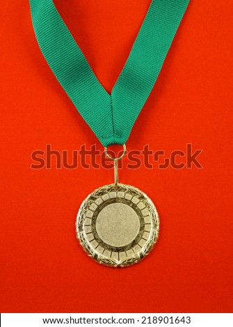Gold medal with green ribbon on red velveteen