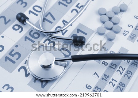 Regular medical examination concept, stethoscope and drugs on calendar