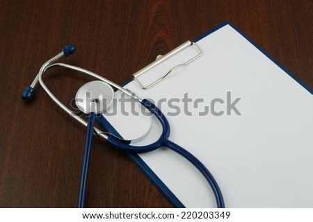Blank clipboard with stethoscope isolated on table
