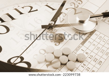 Regular medical examination concept, stethoscope on calendar, drugs and clock