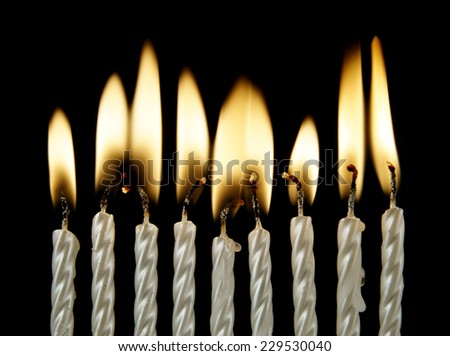 Silver burning candles on black background