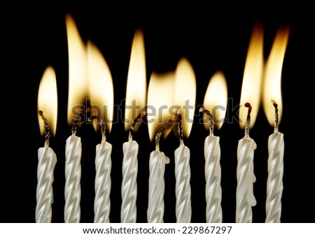 Silver burning candles on black background