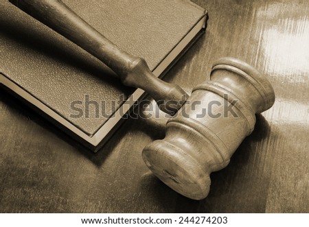 Judge's gavel and legal book on wooden table