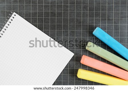 Blank school board with color chalk and blank checked note paper for text