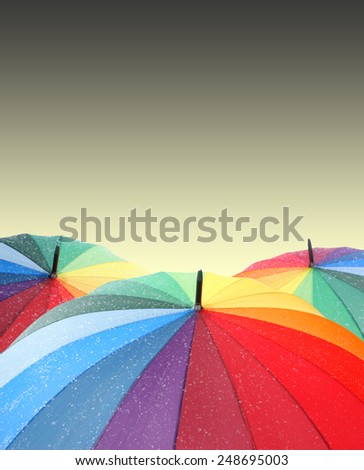 Rainbow umbrellas on sky background