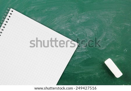 Green school board with chalk and blank checked note paper for text