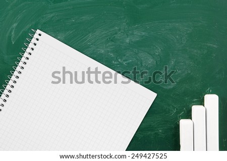 Green school board with chalk and blank checked note paper for text