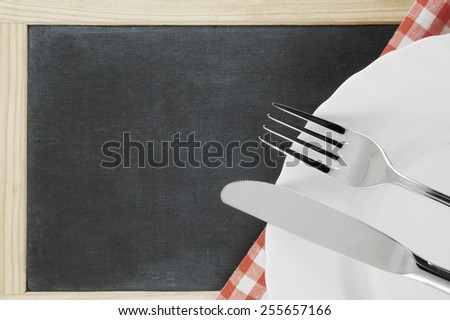 Menu concept with chalk board, plate, knife and fork