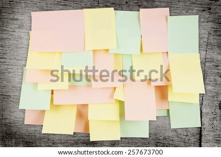 A lot of note papers on grunge wooden background
