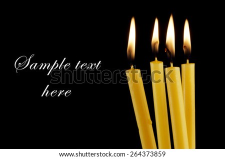 Burning candles isolated on black background with room for text