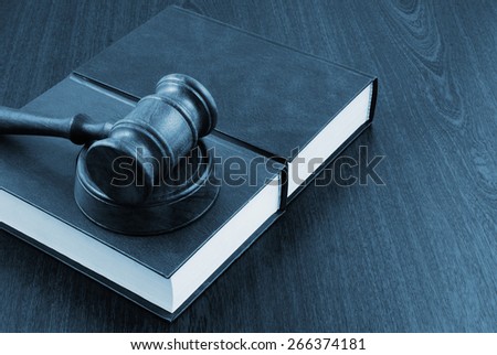 Wooden gavel and legal books on table