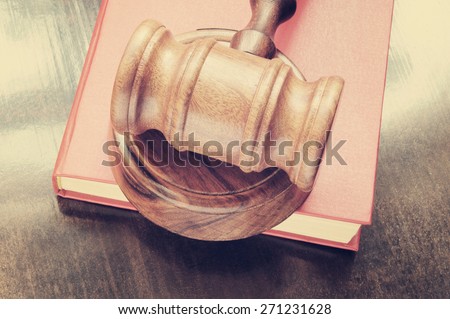 Judge\'s gavel and red legal book on wooden table
