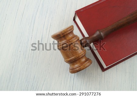 Red legal book and judge wooden gavel on white table with space for text