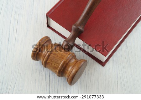 Judge wooden gavel on red legal book