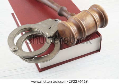 Gavel and handcuffs on legal book