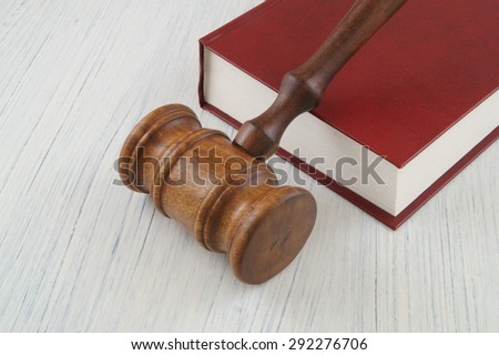 Judge\'s wooden gavel on red legal book, court concept