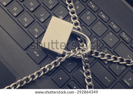 Cyber safety concept, locked chain on laptop computer keyboard