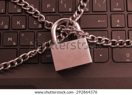Cyber safety concept, locked chain on laptop computer keyboard