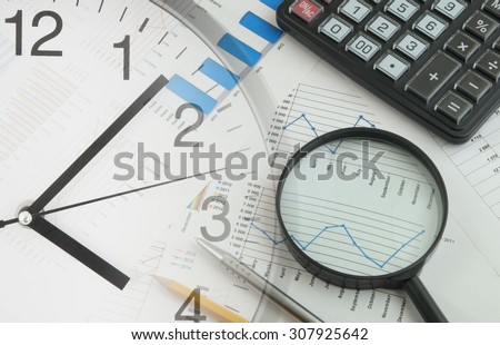 Business concept with charts, graphs, calculator and clock