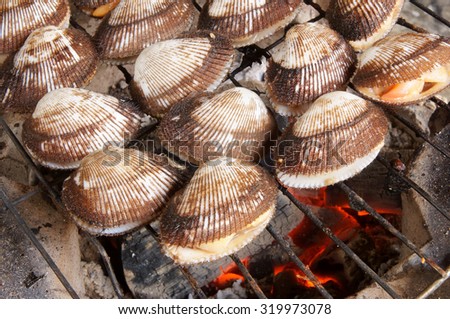 Barbecue grill cooking seafood, cockle seashells cooking on grill