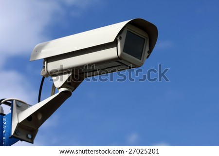 security video camera on background blue sky
