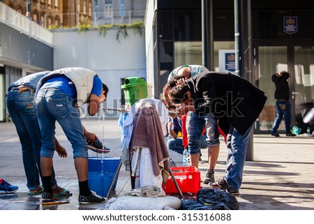 BUDAPEST - SEPTEMBER 7: war refugees bathing and drinking at Keleti Railway Station on 7 September 2015 in Budapest, Hungary. Refugees are arriving constantly to Hungary on the way to Germany.