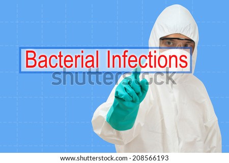 scientist in safety suit pointing to word bacterial infections