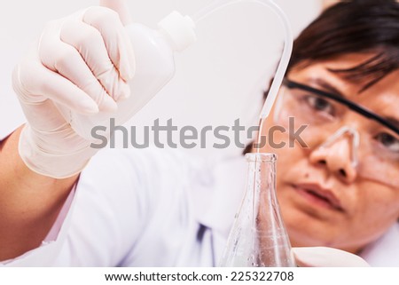 science laboratory worker adding distilled water into flask