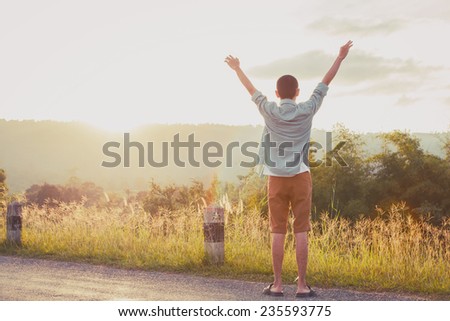 success man hold up hands to sun light