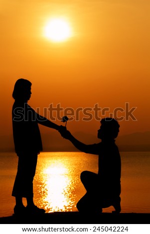 Silhouette of couple in love,Love sensuality and valentine day concept man give woman rose at lake side