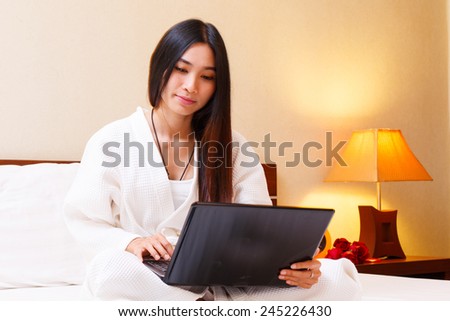 woman use lab top in her nightgown on bed