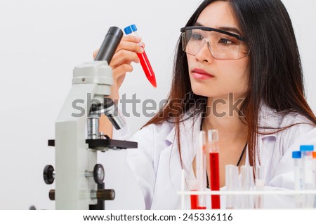 woman working in laboratory,scientist holding red fluid