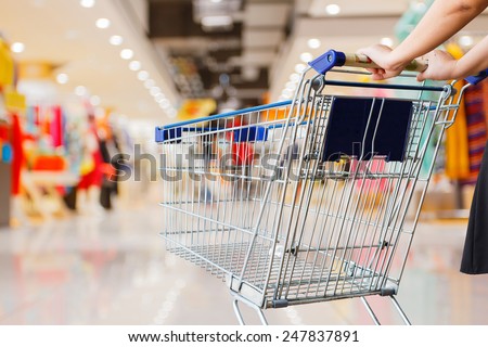 woman pushing shopping cart in shopping mall