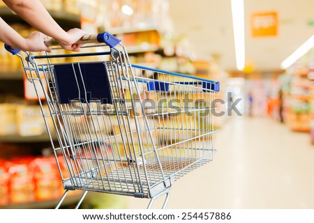 Lady pushing empty shopping cart in the supermarket