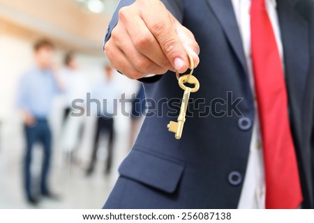 businessman showing the golden key to success