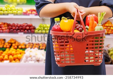 woman holding shopping basket in supermarket,fruit zone background