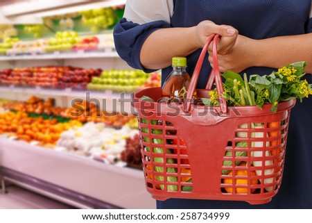 woman holding shopping basket in supermarket,fruit zone background