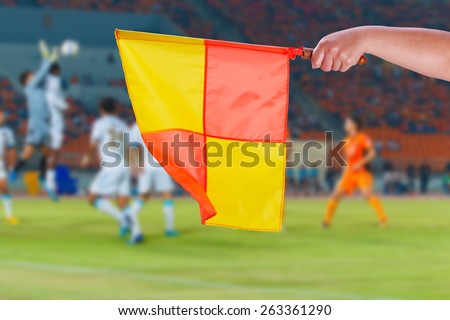 Referee linesman flags for offside or a foul in soccer game