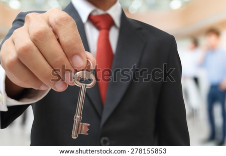 businessman showing the silver key to success