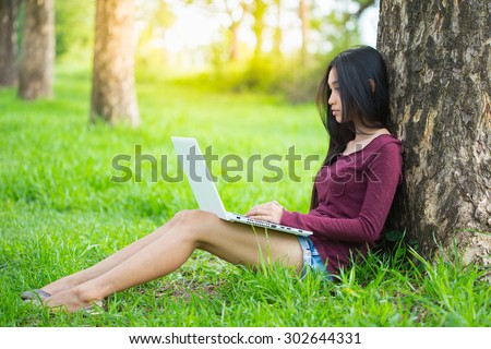 woman with laptop in the park