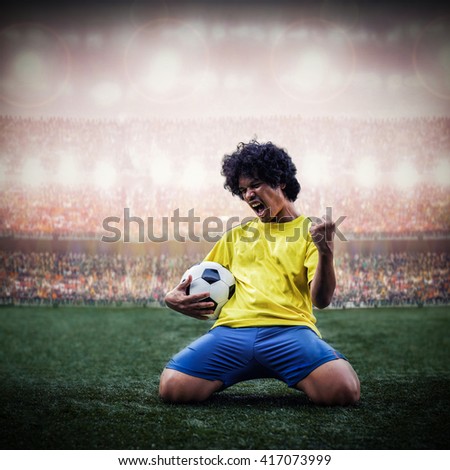 soccer or football player celebrating goal with the ball in hand and knee slide in the stadium