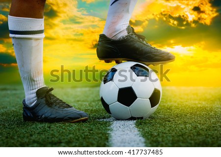 feet of football player tread on soccer ball for kick-off