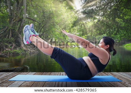 asian fat woman take v shape six pack course in the morning on wooden platform outdoor