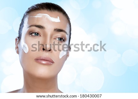 Gorgeous young woman having a spa beauty treatment to her clean face in a skincare and therapy concept, closeup of her face on blue and white